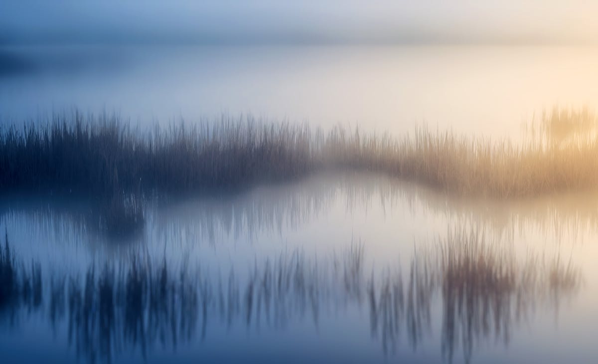 Calm dawn lake water with a faint disturbance on the surface where the thermal spring rises