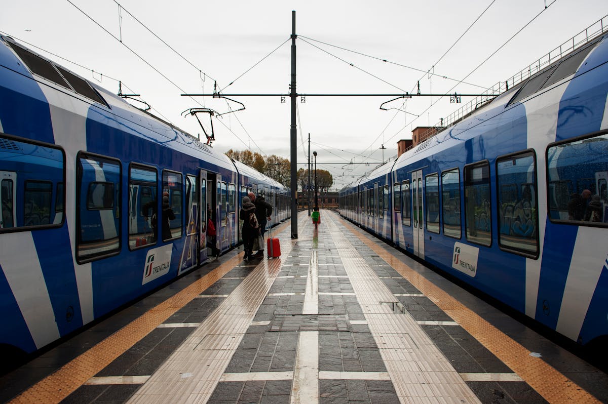 A regional train at Desenzano del Garda station with passengers waiting on the platform